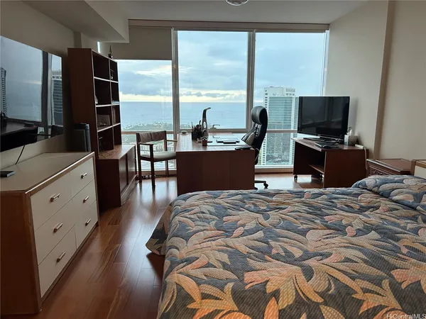 a bedroom with a bed and large windows