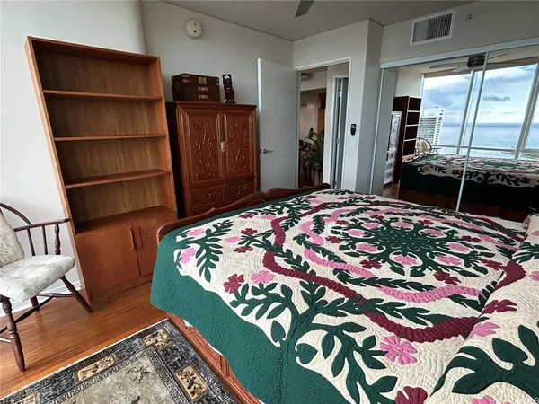 a bedroom with a bed and painting on the wall