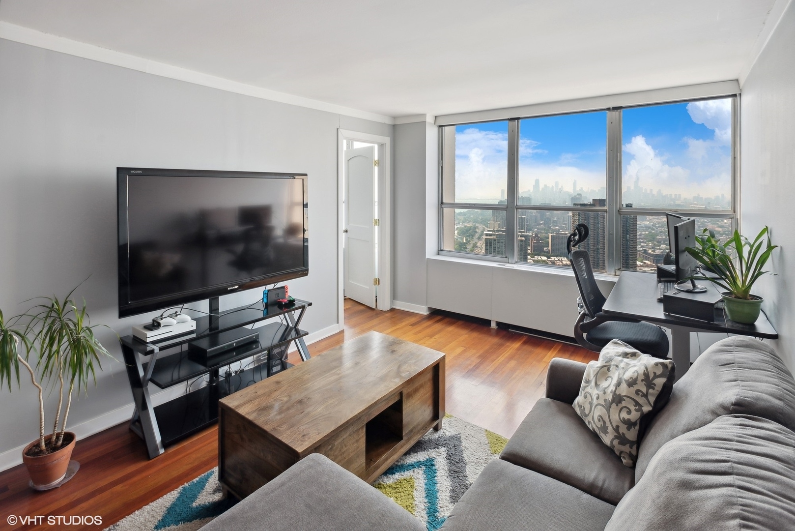 655 West Irving Park Road, Unit 5507 Chicago, IL 60613 - Photo 3 of 17 a living room with furniture and a flat screen tv