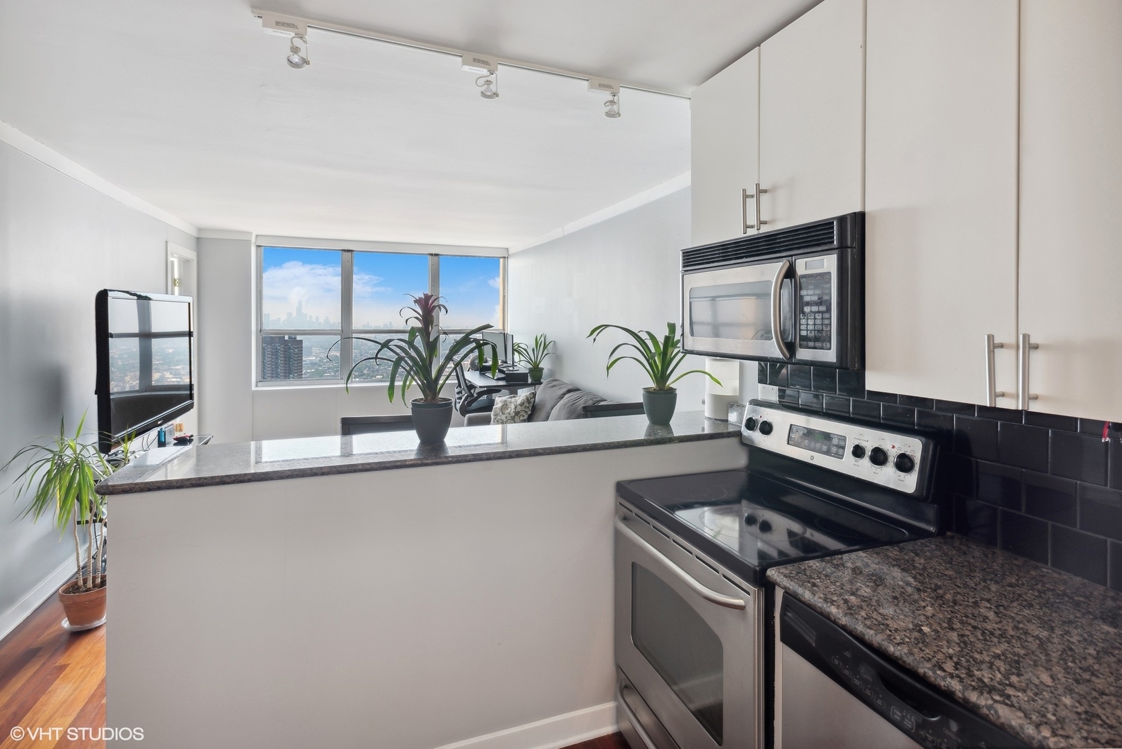 655 West Irving Park Road, Unit 5507 Chicago, IL 60613 - Photo 5 of 17 a kitchen with stainless steel appliances granite countertop a sink stove and cabinets