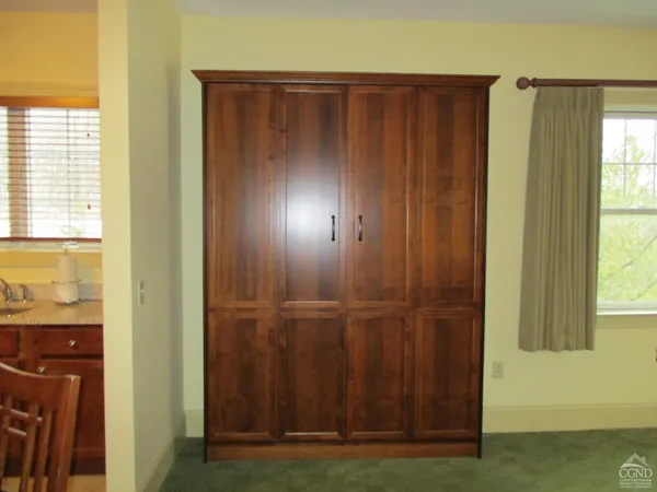 a view of a closet with wooden floor and a cabinet