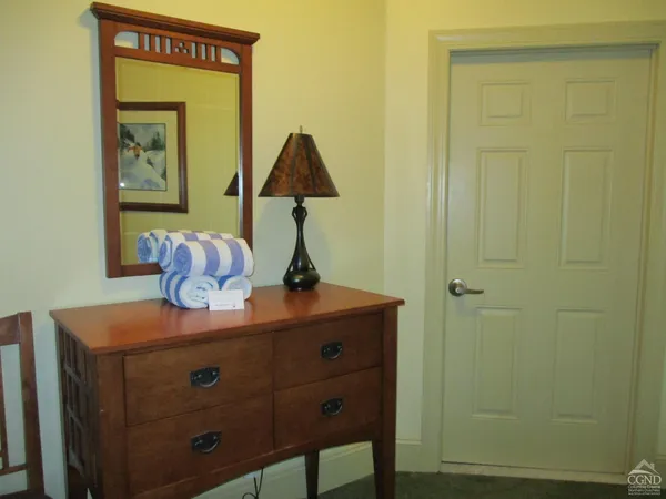 a view of hallway that has closet and a mirror