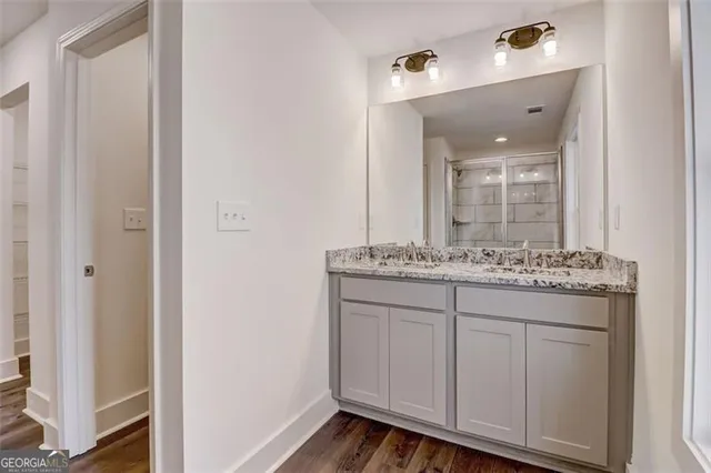 a bathroom with a granite countertop sink and a mirror