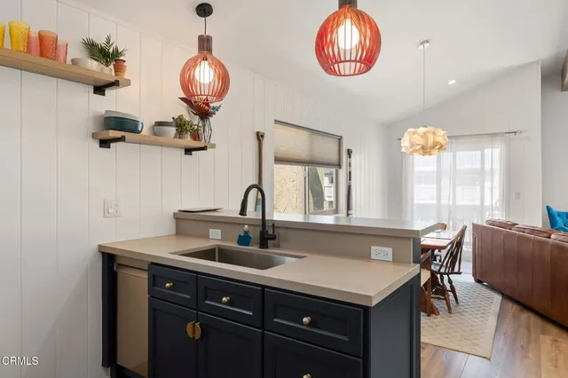 a bedroom with a bed a table and three large window
