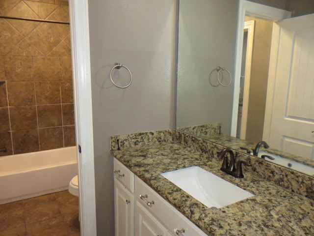 2607 Alan Lake Lane Spring, TX 77388 - Photo 30 of 42 a bathroom with a granite countertop sink a mirror and a bathtub