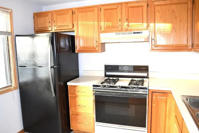 a kitchen with stainless steel appliances granite countertop a stove and a refrigerator with cabinets