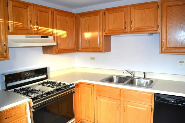 a kitchen with stainless steel appliances granite countertop a sink stove and cabinets