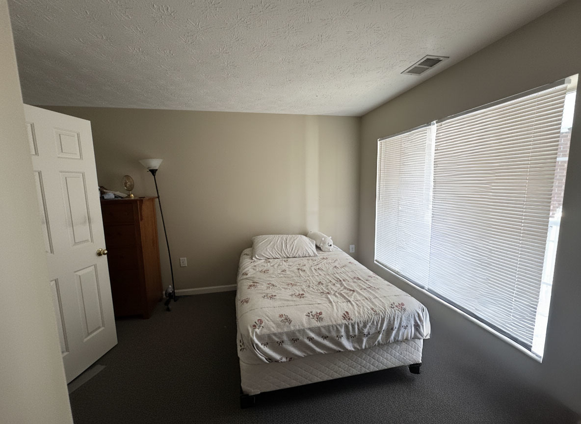 1905 North Lincoln Avenue, Unit 319 Urbana, IL 61801 - Photo 7 of 10 a bedroom with a bed and a refrigerator