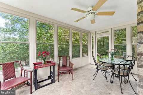 a dining room with furniture and a floor to ceiling window