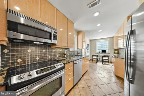 a kitchen with kitchen island granite countertop a sink and a stove