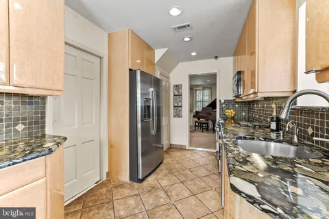 a kitchen with stainless steel appliances kitchen island granite countertop a sink and cabinets