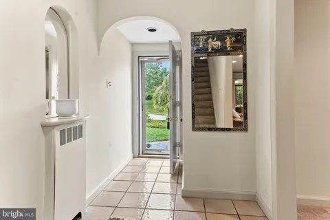 a view of a hallway with wooden floor and a bathroom