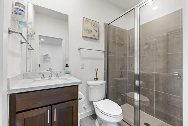 a bathroom with a sink a toilet and shower