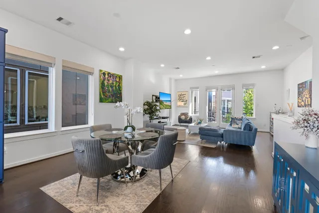 a living room with furniture wooden floor and a large window