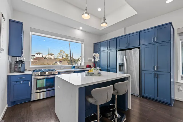 a kitchen with stainless steel appliances granite countertop a table chairs stove and refrigerator