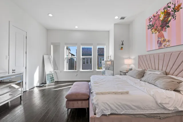 a bedroom with a bed wall painting and a window