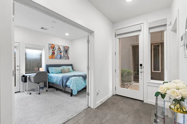 a spacious bedroom with a bed and a painting on the wall