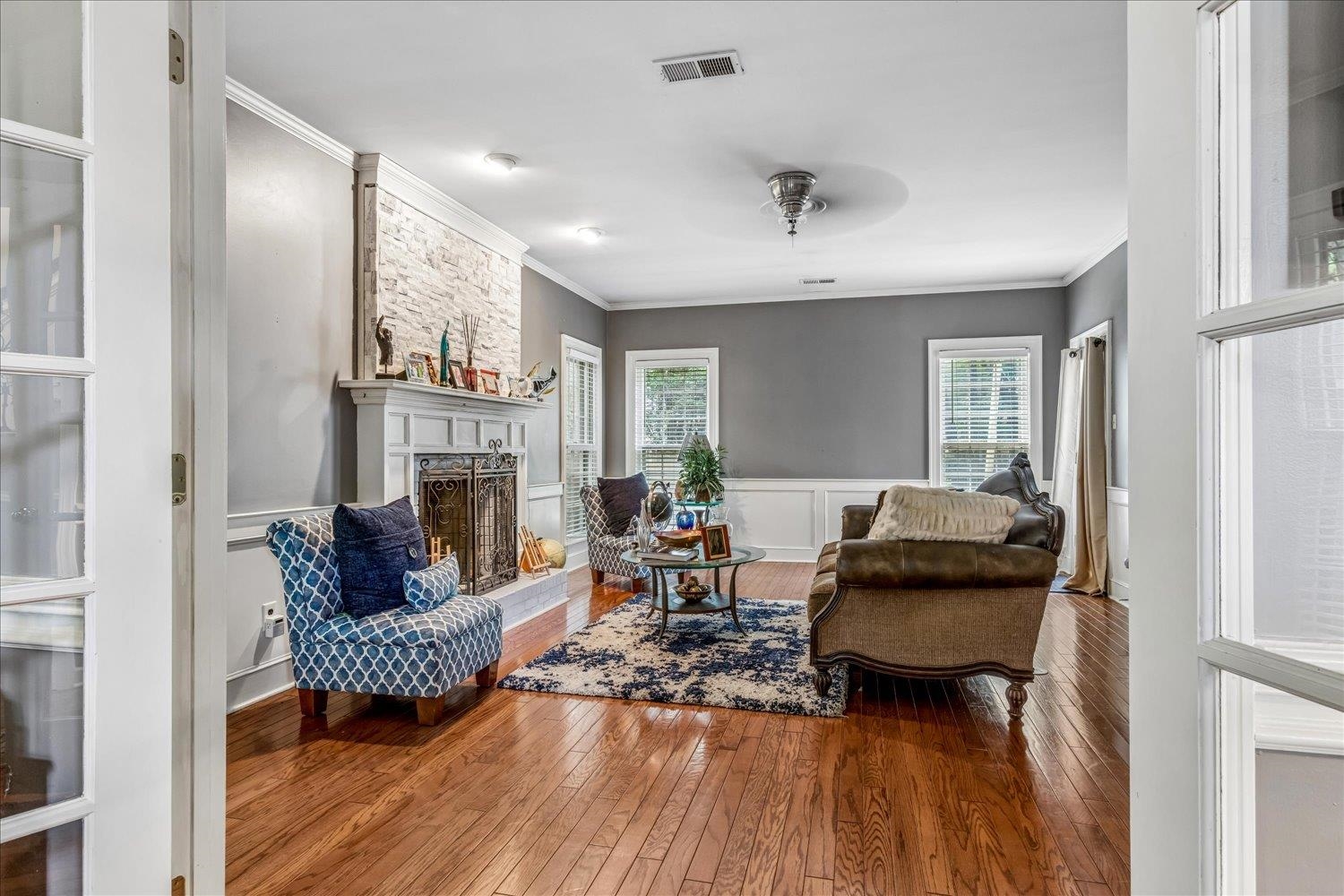 65 Summer Grove Road Memphis, TN 38018 - Photo 11 of 38 Hardwood flooring throughout, a stone-faced fireplace with a substantial mantel, and white wainscoting