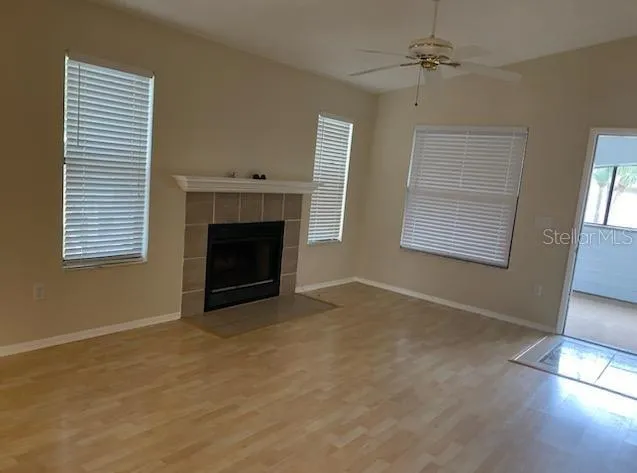a view of empty room with fireplace and wooden floor