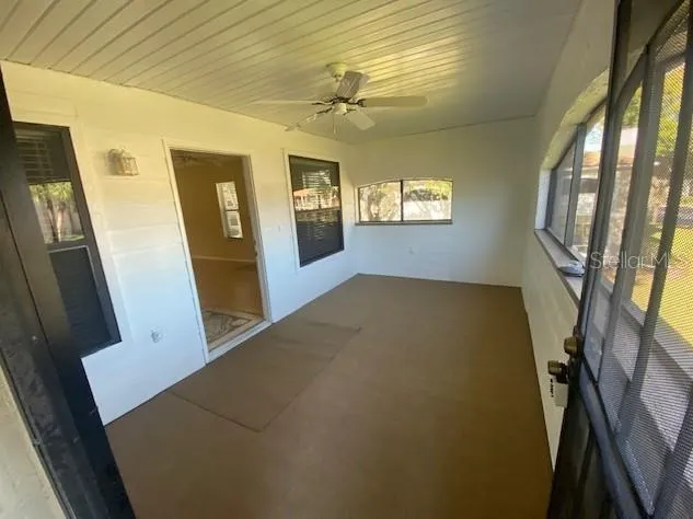 a view of a hallway to a livingroom with furniture