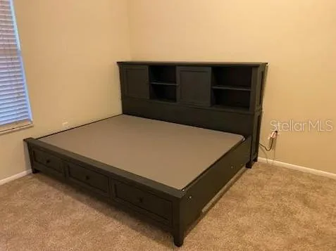 a bed sitting in a bedroom next to a window