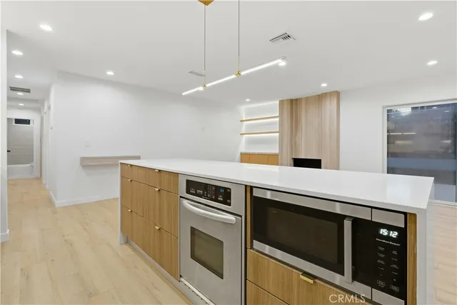 a large kitchen with stainless steel appliances granite countertop a large counter top a sink and a stove