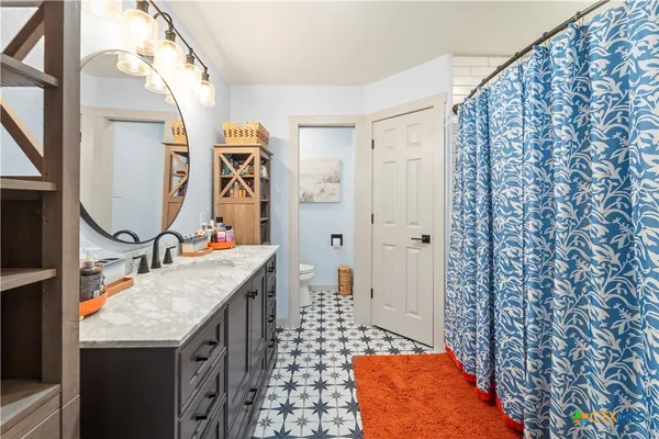 a bathroom with a granite countertop sink and a mirror