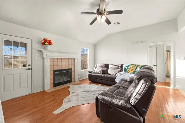 a living room with furniture fireplace and a window