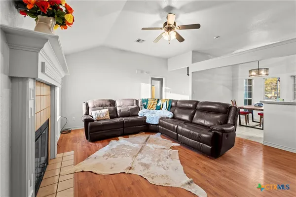 a living room with furniture a fireplace and a chandelier