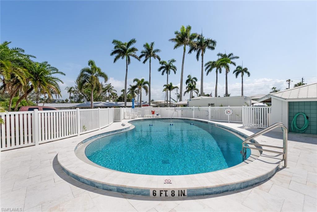 2011 Gulf Shore Boulevard North, Unit 45 Naples, FL 34102 - Photo 14 of 16 a view of a swimming pool with a lounge chair