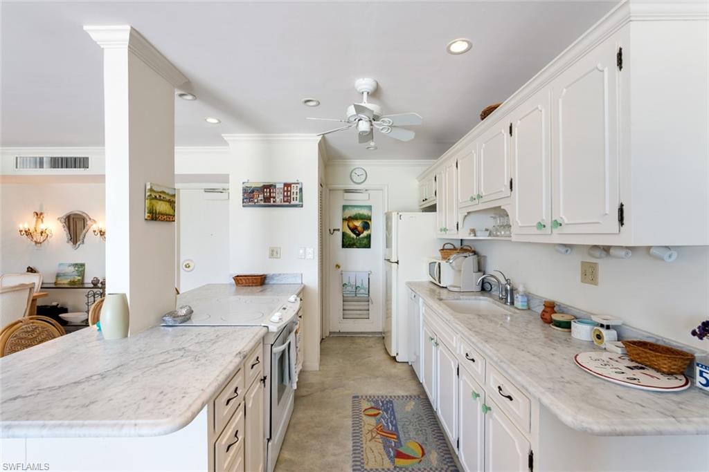 2011 Gulf Shore Boulevard North, Unit 45 Naples, FL 34102 - Photo 7 of 16 a kitchen with stainless steel appliances granite countertop a sink stove and refrigerator