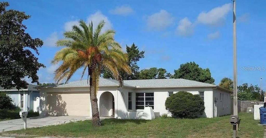 9641 Morehead Lane Port Richey, FL 34668 - Photo 1 of 1 a view of a white house with a yard and potted plants