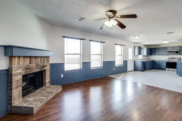 an empty room with windows and a fireplace