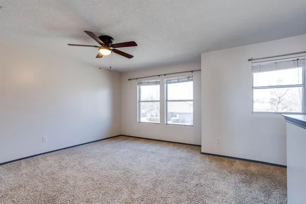 a view of a livingroom with a ceiling fan and window