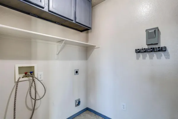a view of an empty room and chandelier fan