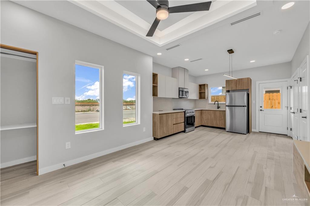 11411 North 24th Lane, Unit A McAllen, TX 78504 - Photo 3 of 24 a view of a kitchen with stainless steel appliances kitchen island wooden floors cabinets and a window