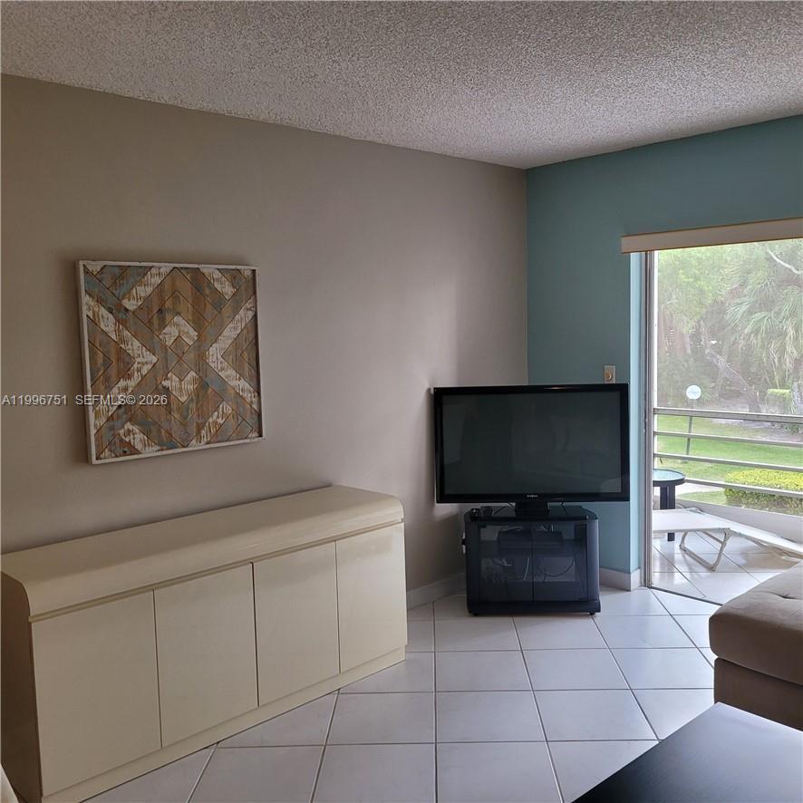 3774 Inverrary Boulevard, Unit 206P Lauderhill, FL 33319 - Photo 12 of 17 a living room with furniture and a flat screen tv