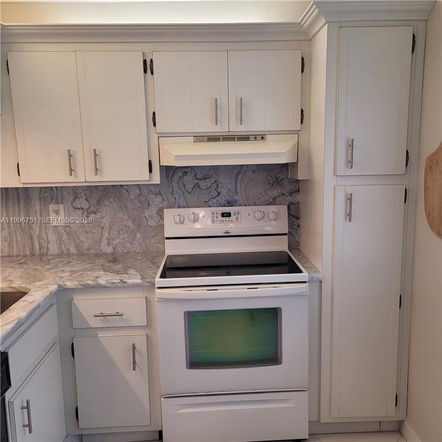 3774 Inverrary Boulevard, Unit 206P Lauderhill, FL 33319 - Photo 4 of 17 a kitchen with granite countertop white cabinets and a stove with a sink