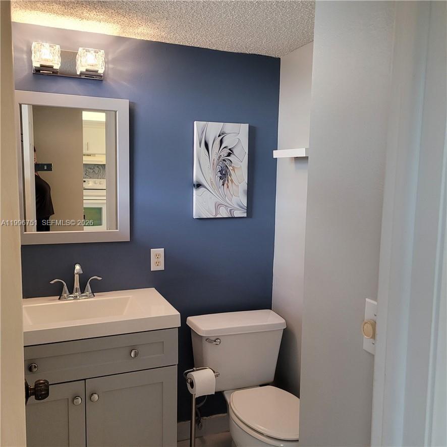 3774 Inverrary Boulevard, Unit 206P Lauderhill, FL 33319 - Photo 7 of 17 a bathroom with a toilet sink and mirror