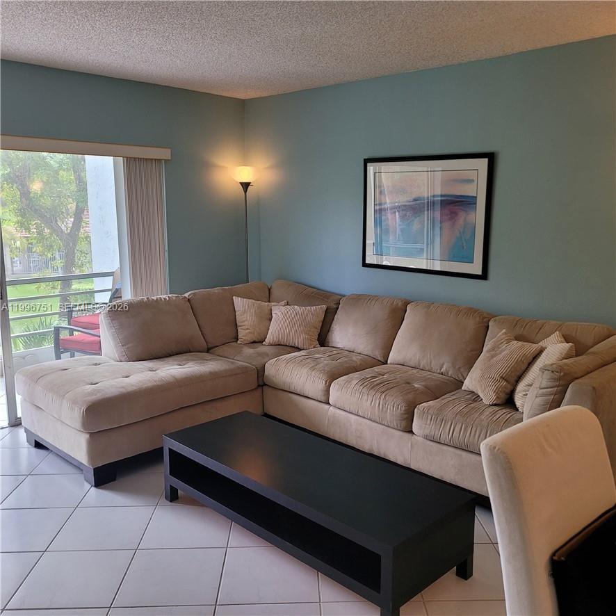 3774 Inverrary Boulevard, Unit 206P Lauderhill, FL 33319 - Photo 8 of 17 a living room with furniture and a large window