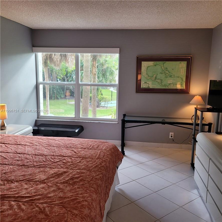 3774 Inverrary Boulevard, Unit 206P Lauderhill, FL 33319 - Photo 10 of 17 a bedroom with a bed and a large window