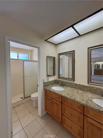 a spacious bathroom with a granite countertop sink and a mirror