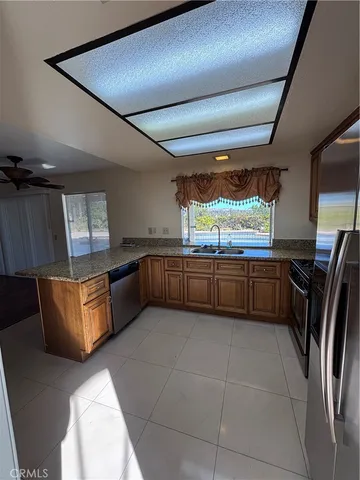 a kitchen with a sink a counter top space and stainless steel appliances