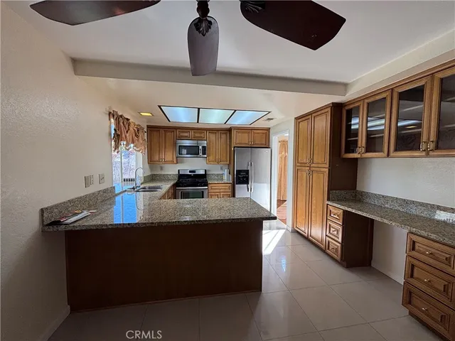 a kitchen with stainless steel appliances granite countertop a sink a stove and a refrigerator