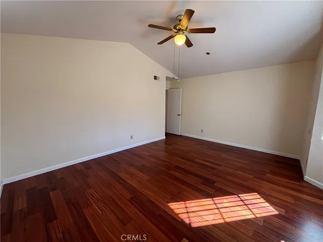 a view of room with hardwood floor and a ceiling fan
