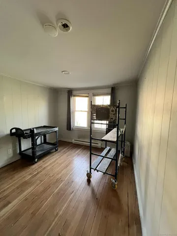 a living room with chairs and a wooden floor