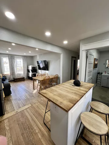 a view of a kitchen with kitchen island a stove a sink a table and chairs