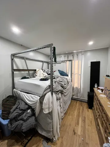 a bedroom with a bed and wooden floor