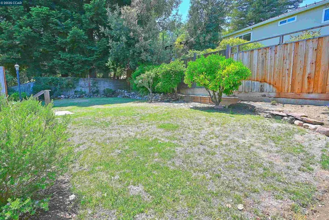 a kitchen with stainless steel appliances granite countertop a stove a sink dishwasher and a refrigerator with wooden floor