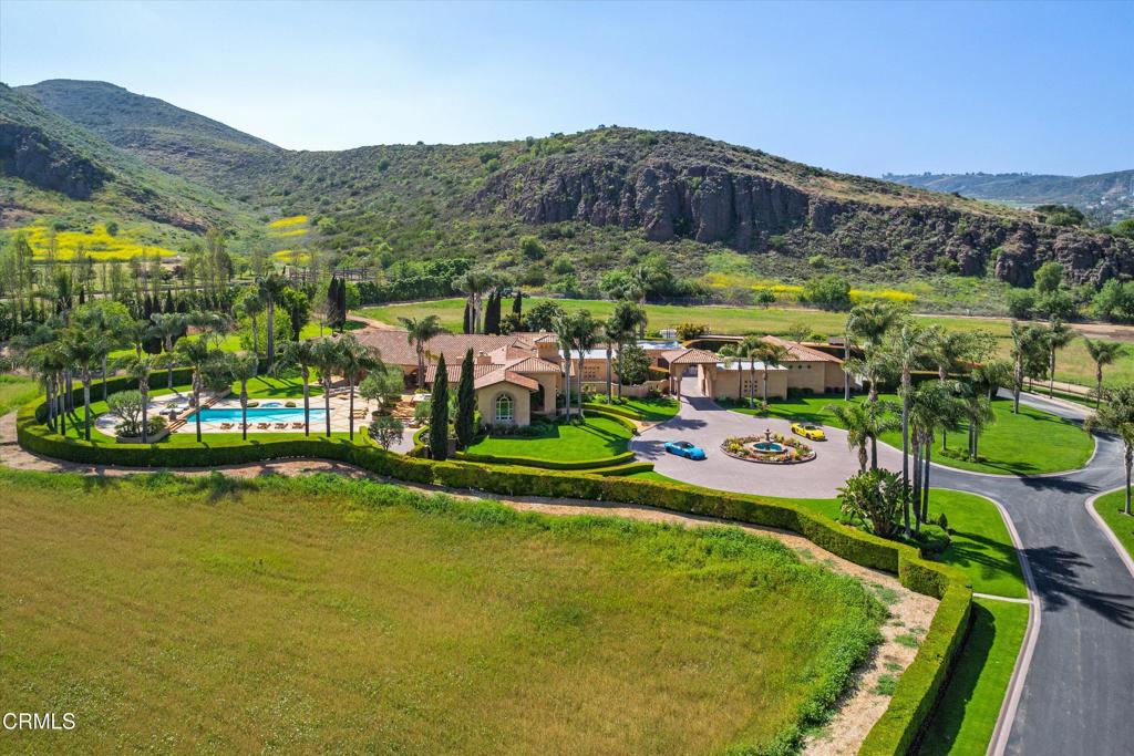 11113 Rocky High Road Camarillo, CA 93012 - Photo 2 of 48 a view of a swimming pool with a table and chairs under an umbrella